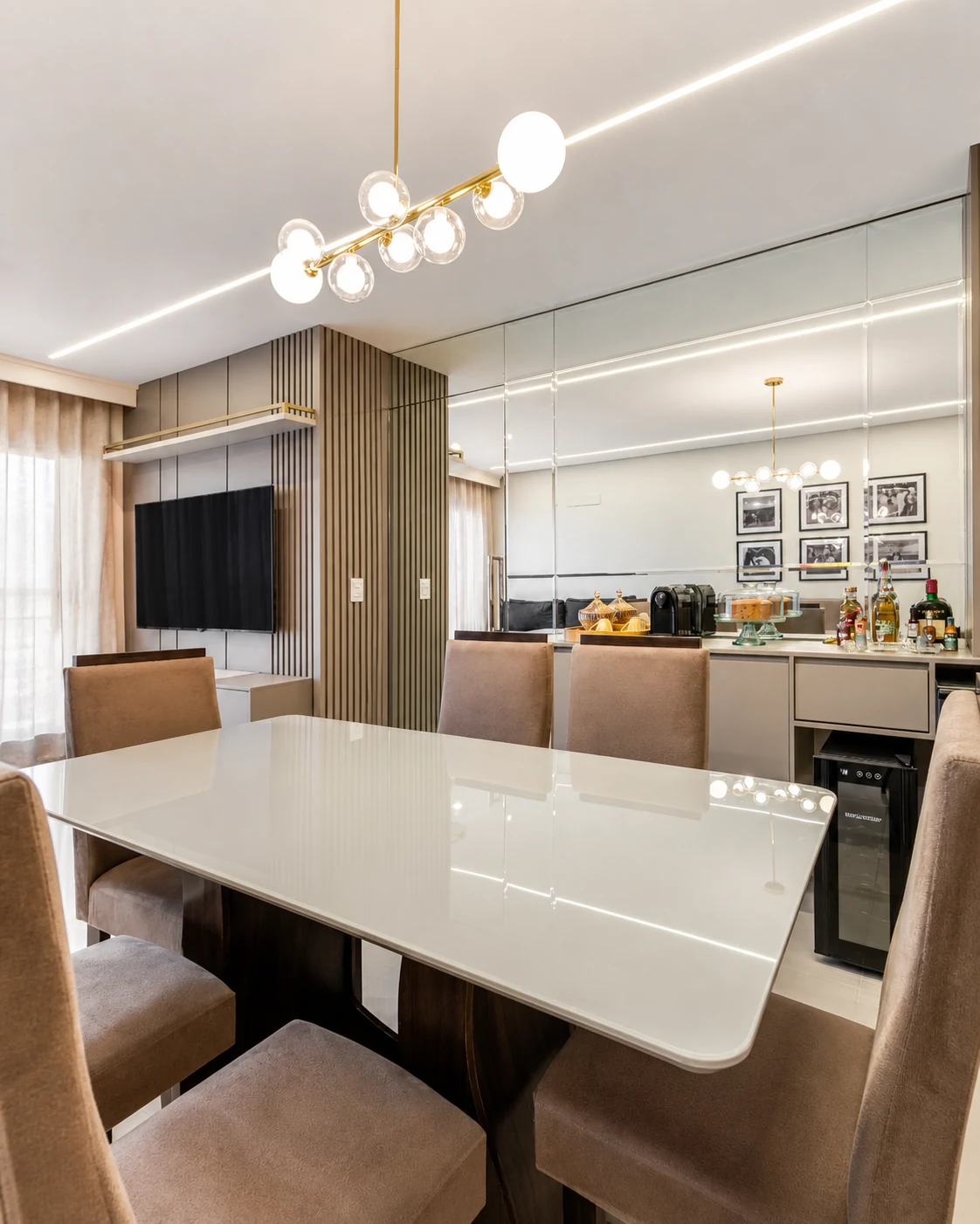 Sala de jantar integrada com painel ripado, espelhos e marcenaria sob medida